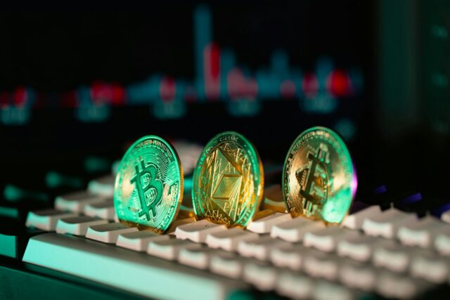 Photo by Jakub Żerdzicki Cryptocurrency coins sit on a keyboard.